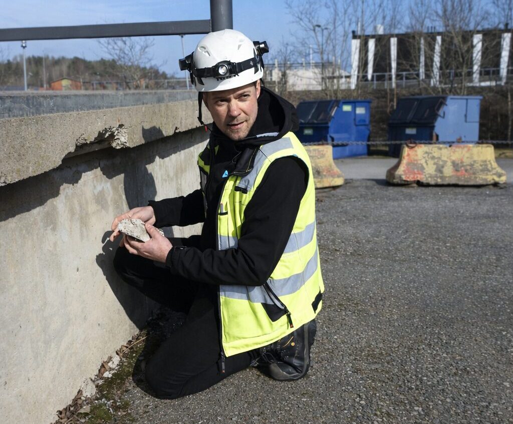 Rakennustarkastaja tarkistaa vaurioitunutta betonia